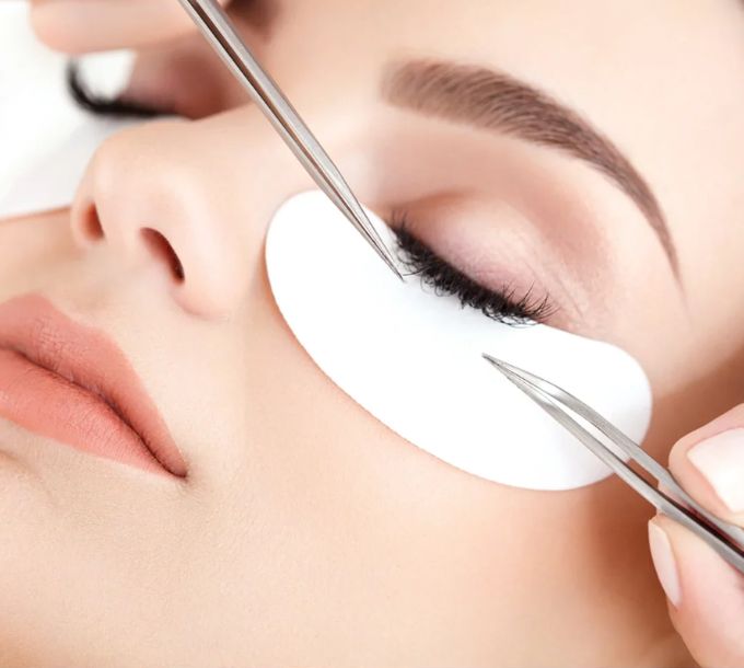 Classic eyelash extensions being applied with tweezers