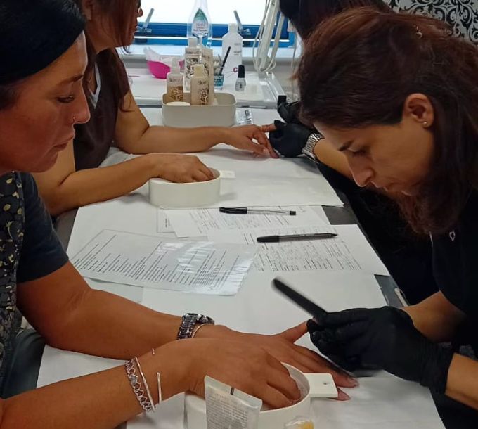 Students practising manicures at training desks