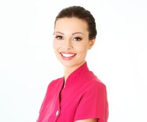 Smiling beauty therapist in a pink tunic