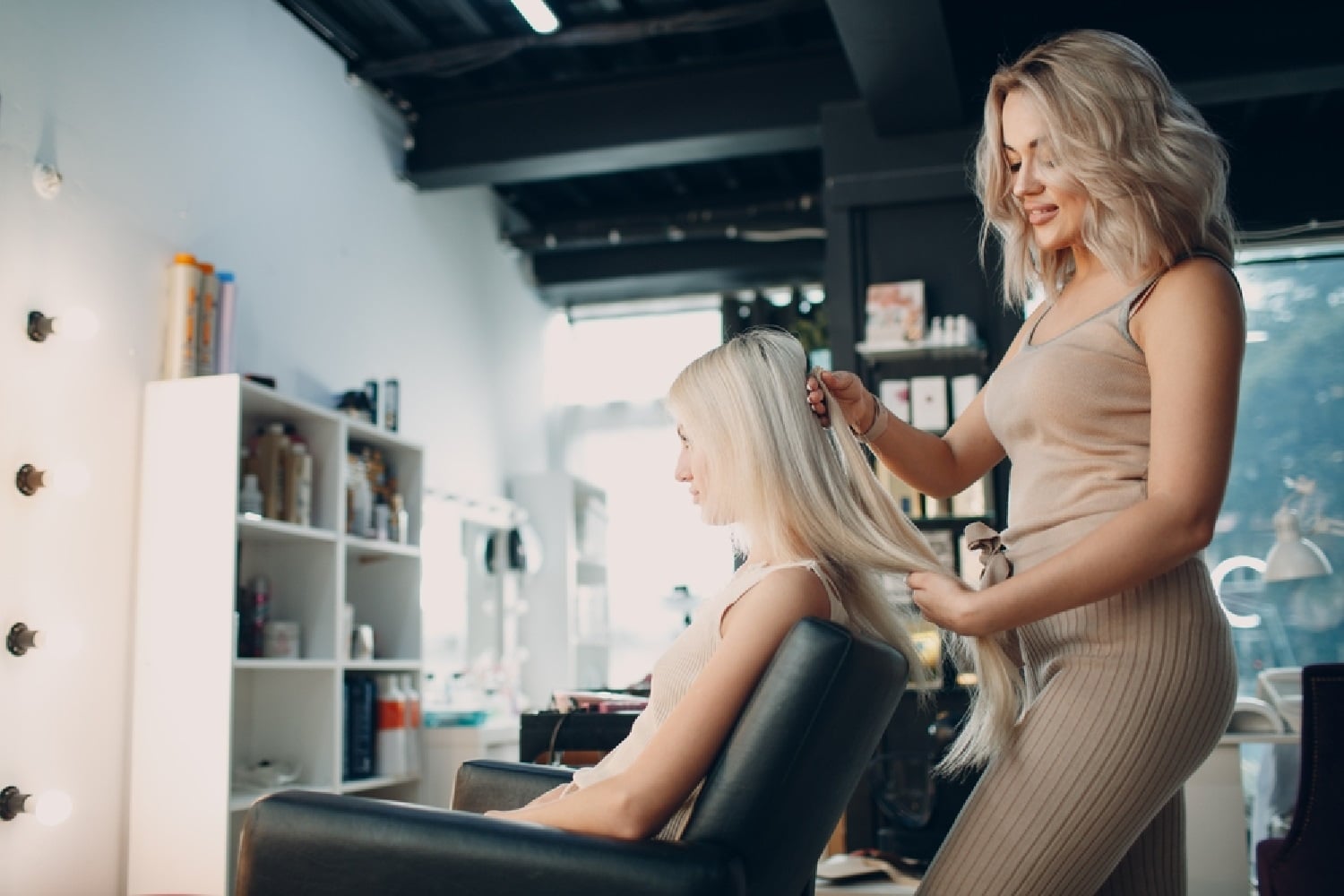 Hair technician styling a client's hair in a salon