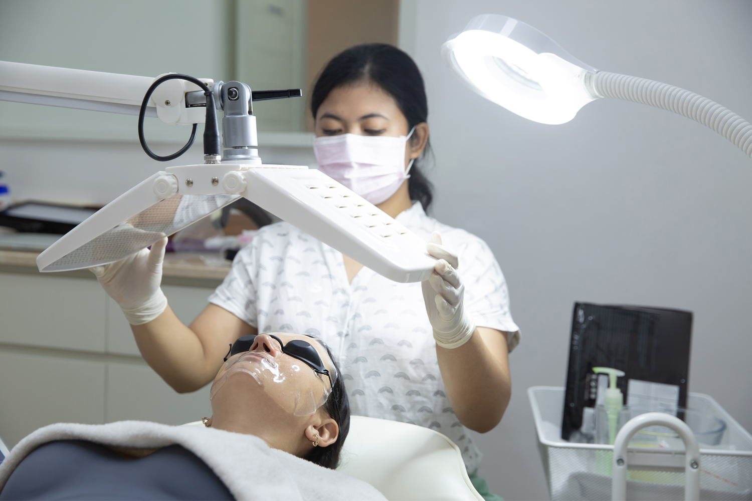Therapist preparing an LED light therapy facial